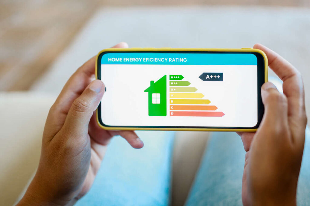 Skala efektywności energetycznej na telefonie ilustrująca energielabel mieszkania