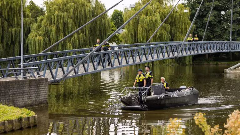 Policjanci na łodzi podczas poszukiwań broni w Ringvaartplas w Rotterdamie
