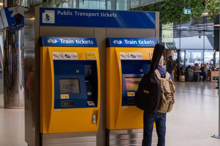 Pasażer kupujący bilet kolejowy w automacie NS na stacji w Holandii