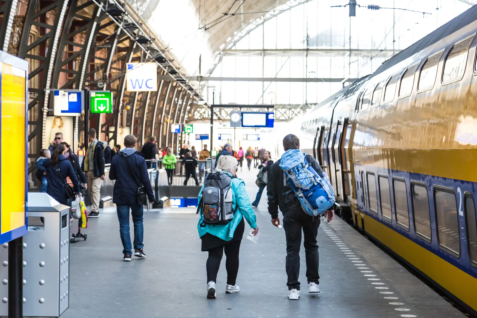 Pasażerowie na peronie Amsterdam Centraal przed pociągiem NS