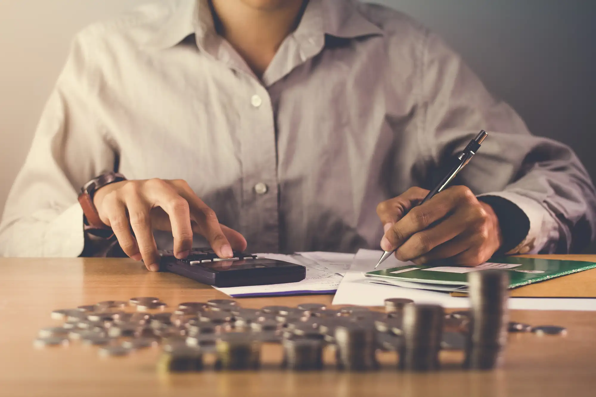Osoba obliczająca podatek przy kalkulatorze i dokumentach finansowych
