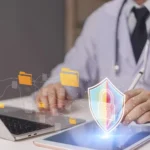 Lekarz przy komputerze z symbolem ochrony danych medycznych i cyberbezpieczeństwa