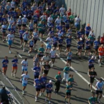 Uczestnicy biegu Dam tot Damloop biegną ulicą w Amsterdamie w kierunku Zaandam.