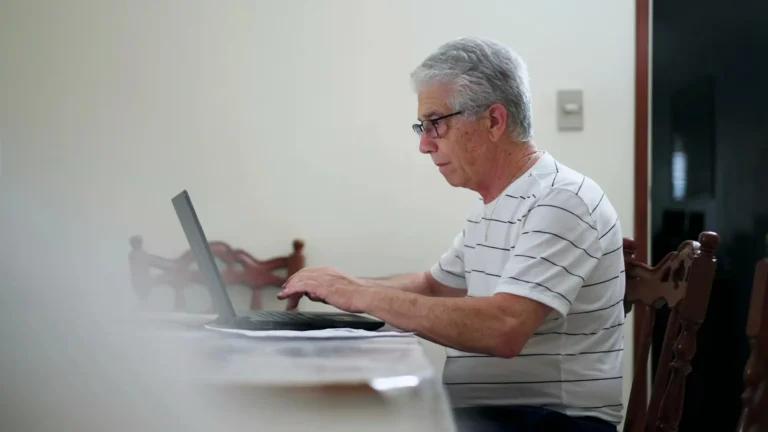 Senior korzystający z laptopa w domu – DigiD można teraz używać bez smartfona