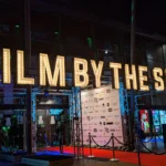 Podświetlony napis Film by the Sea nad wejściem na festiwal filmowy we Vlissingen w Holandii.