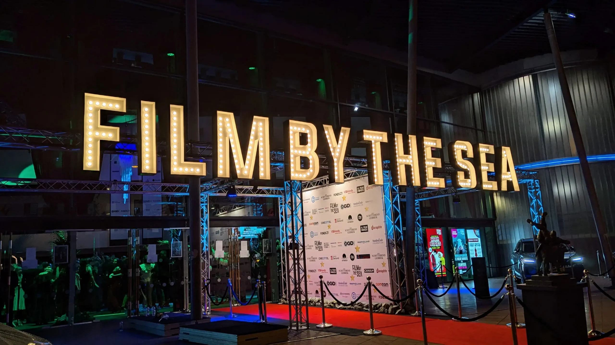 Podświetlony napis Film by the Sea nad wejściem na festiwal filmowy we Vlissingen w Holandii.