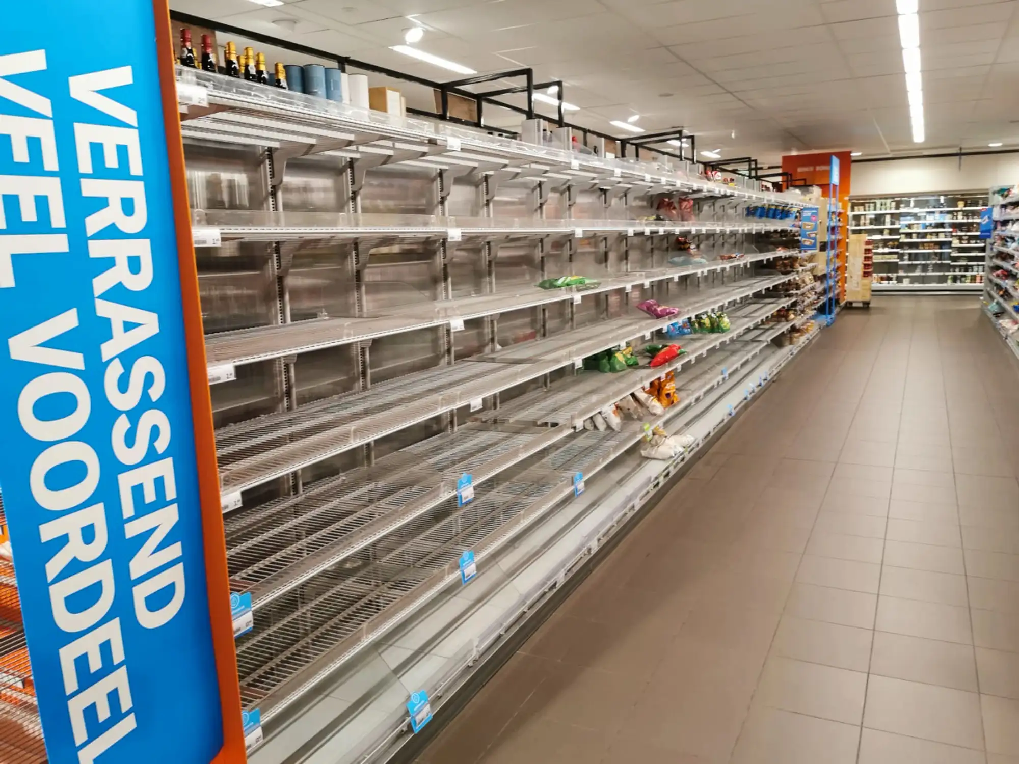 Puste półki z żywnością w supermarkecie. Holenderscy eksperci zalecają domowe zapasy na osiem dni.
