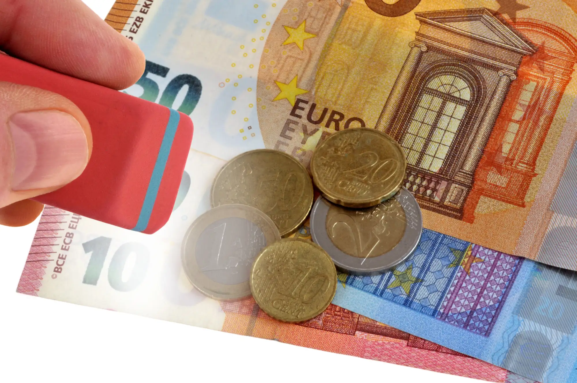 Gumka nad banknotami euro i monetami symbolizująca korektę rozliczenia
