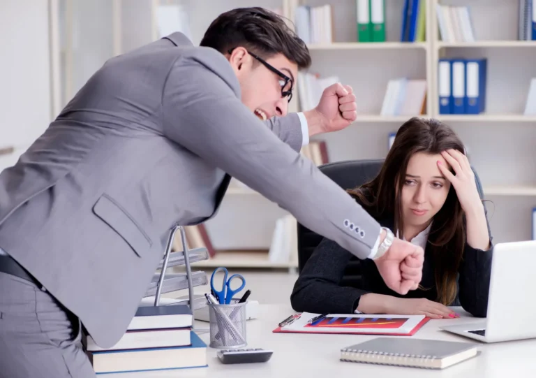 Przełożony krzyczący na pracownicę przy biurku