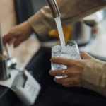 Nalewanie wody z kranu do szklanki w domowej kuchni