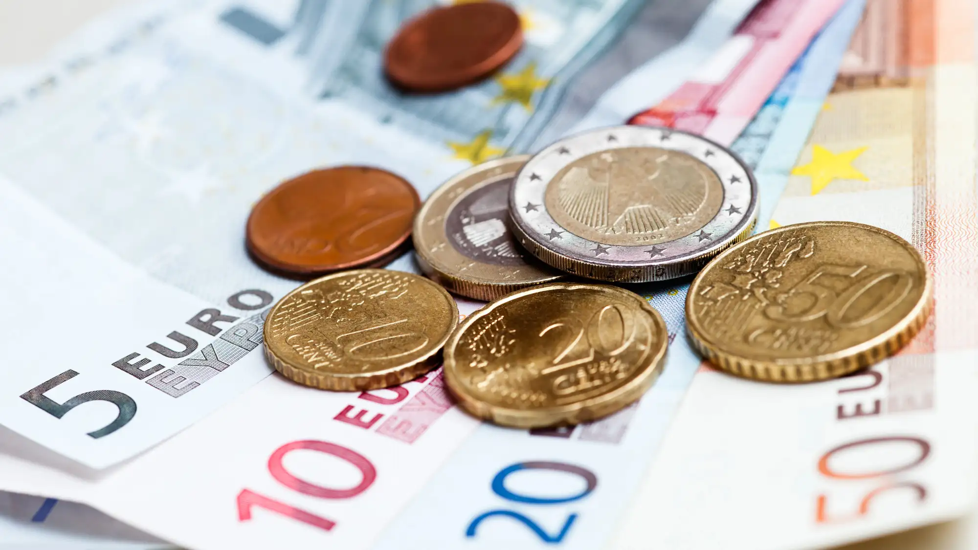 Banknoty i monety euro symbolizujące płacę minimalną w Holandii