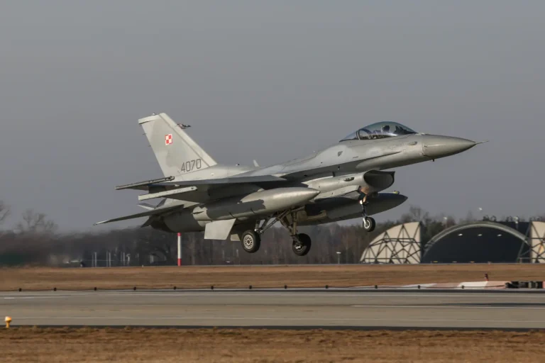 Polski myśliwiec F-16 z wysuniętym podwoziem podczas podejścia do lądowania.