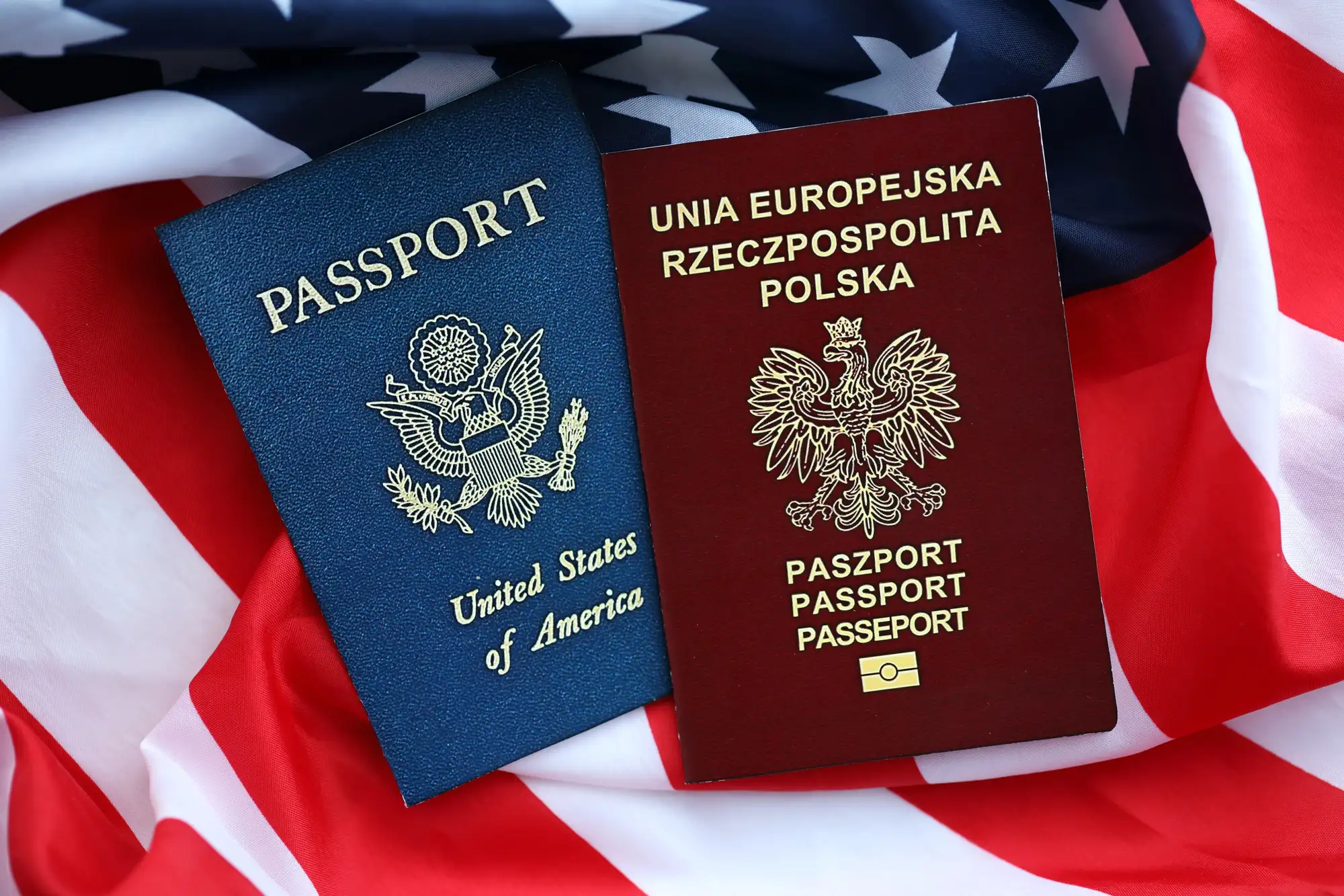 Paszport Polski i paszport Stanów Zjednoczonych na tle flagi USA