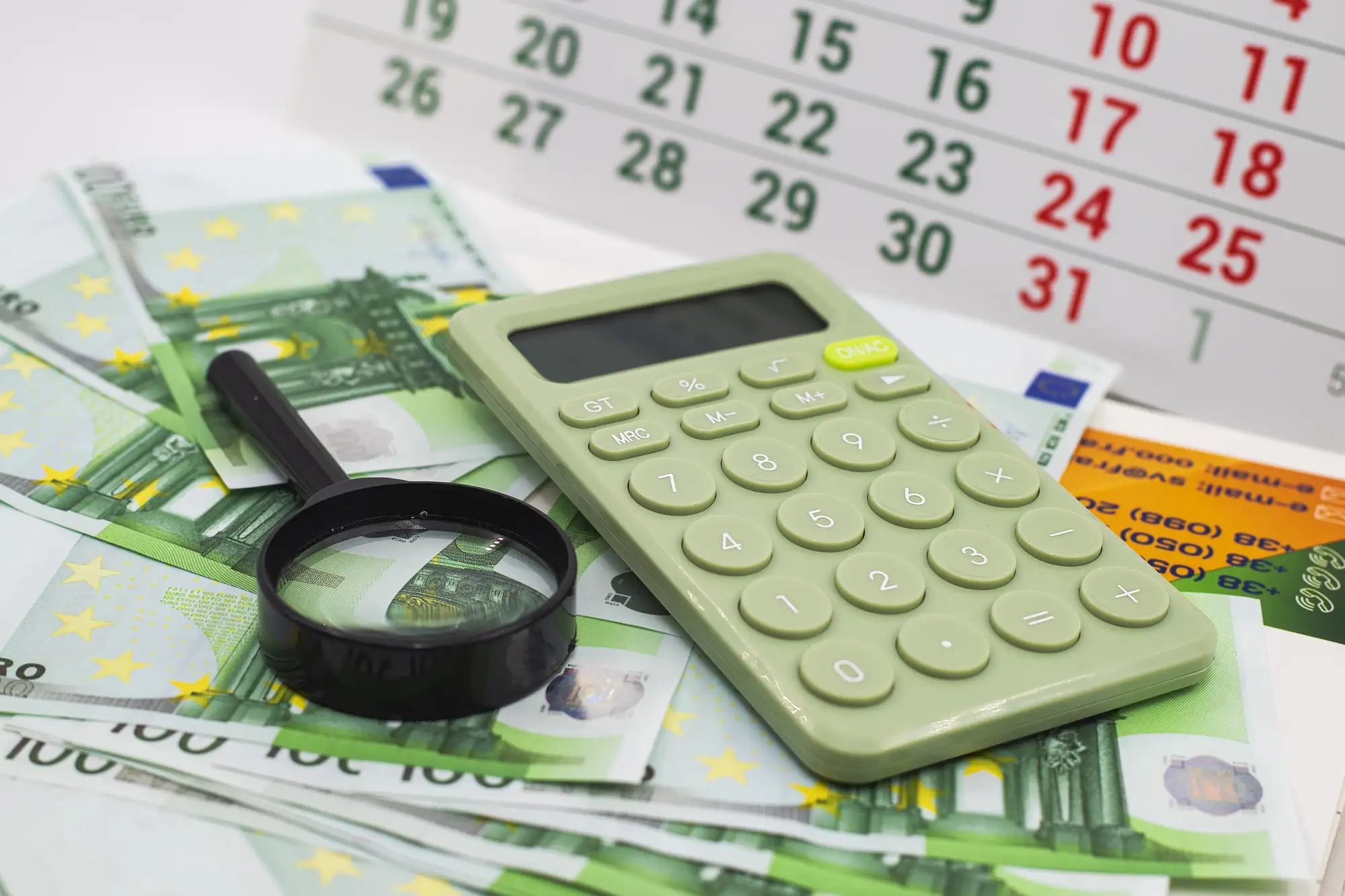 Kalendarz, kalkulator i banknoty euro symbolizujące zaliczki podatkowe