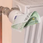 Termostat grzejnikowy z banknotem 100 euro symbolizujący rosnące ceny gazu i koszty ogrzewania w Holandii w 2026 roku.