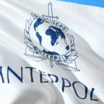 Flaga Interpolu z emblematem organizacji