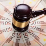 Młotek sędziowski na banknotach 50 euro symbolizujący wyrok TSUE dotyczący zwrotu skradzionych pieniędzy przez bank.